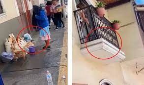 Una mujer tira agua desde su balcón en fiestas de Huaquillas